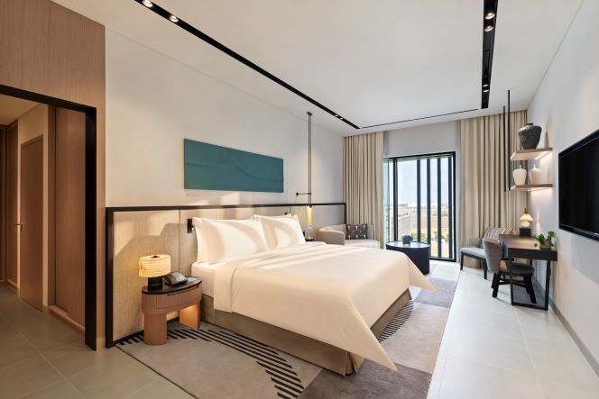 A contemporary five-star hotel building with a swimming pool and outdoor terrace in a modern urban development.