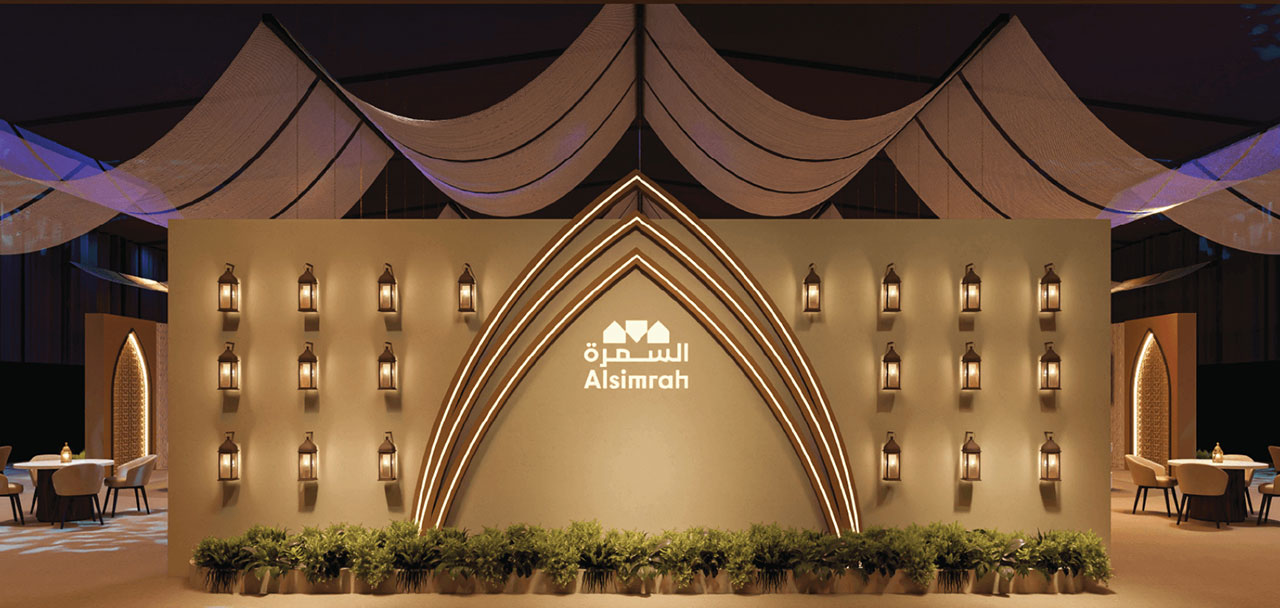 A large, elegantly decorated Ramadan tent with Middle Eastern architectural details and outdoor seating areas at night.