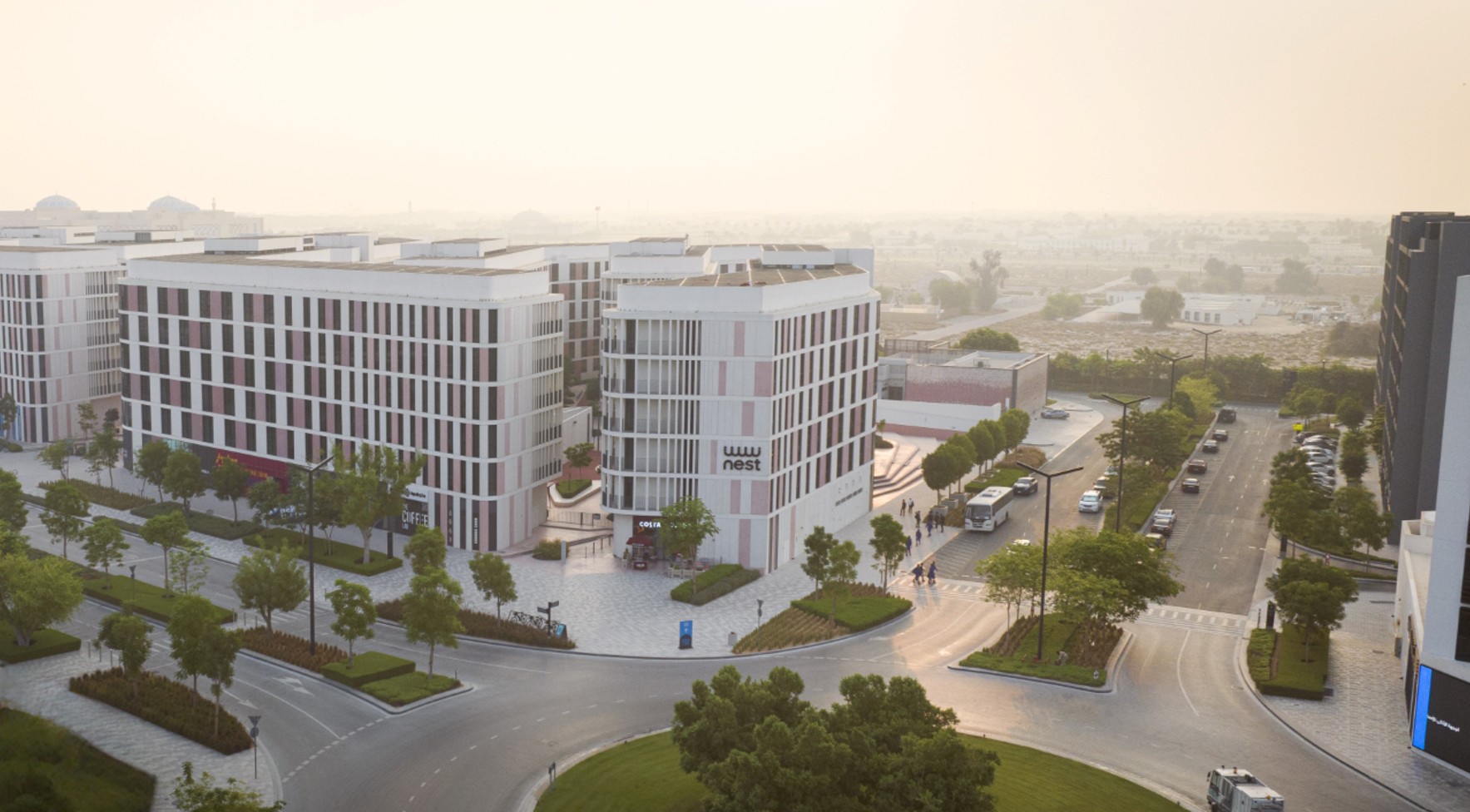A modern hotel room interior with a balcony view overlooking the Aljada development and East Boulevard.