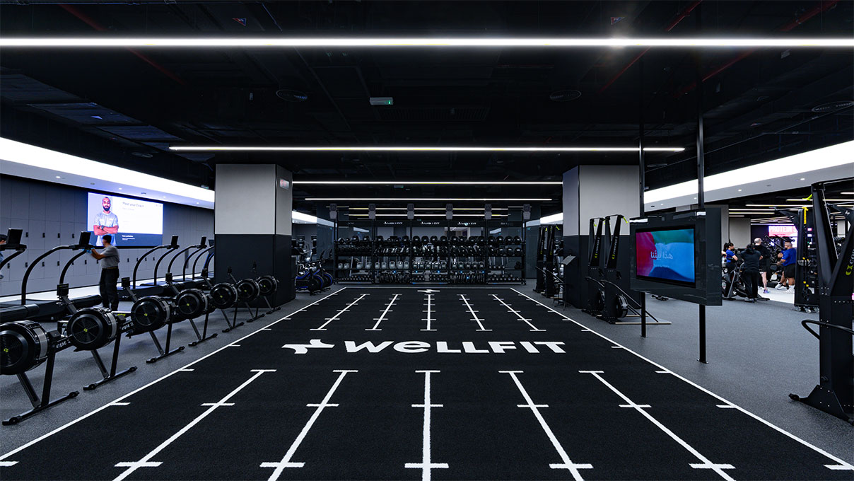 A large, modern fitness centre interior with rows of cardio machines, strength equipment, and dedicated functional