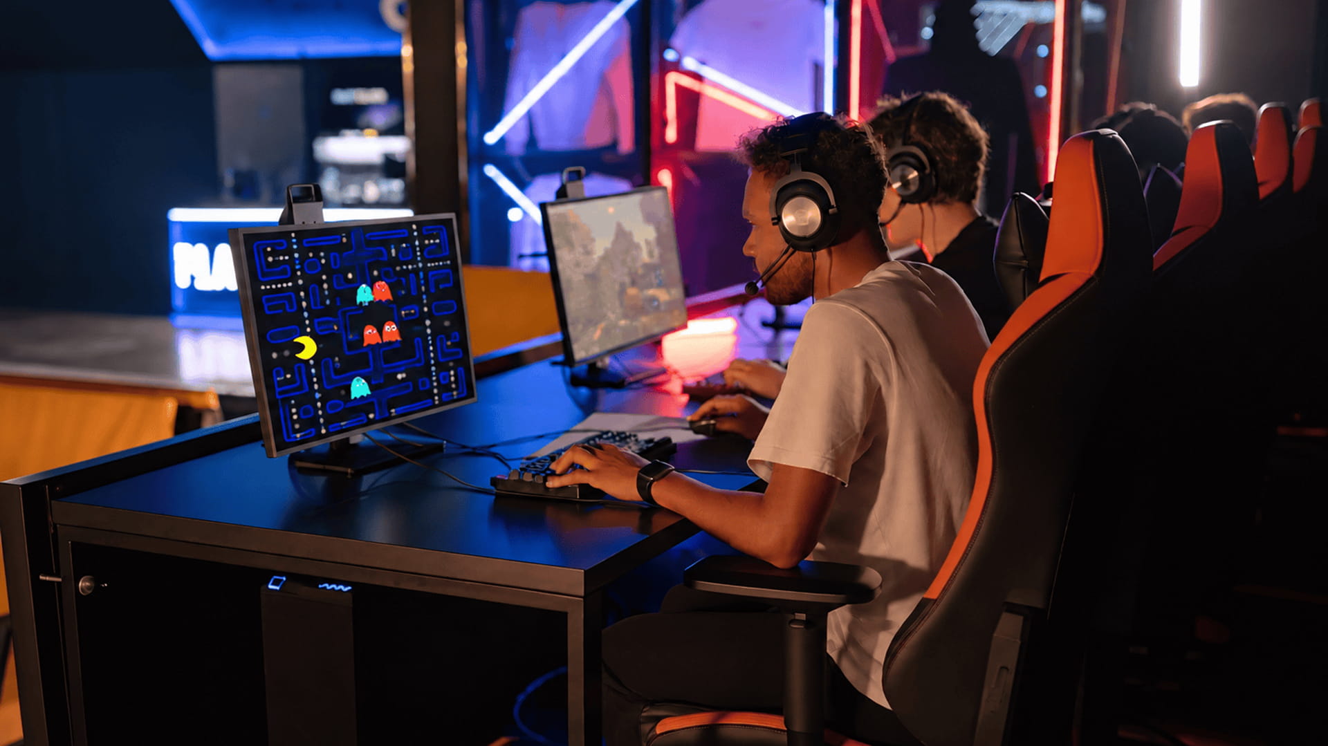 Players competing in an esports tournament on a stage with large screens and gaming consoles.