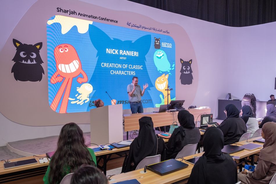 A creative workshop setting with artists drawing and digital animation equipment on display at a conference.