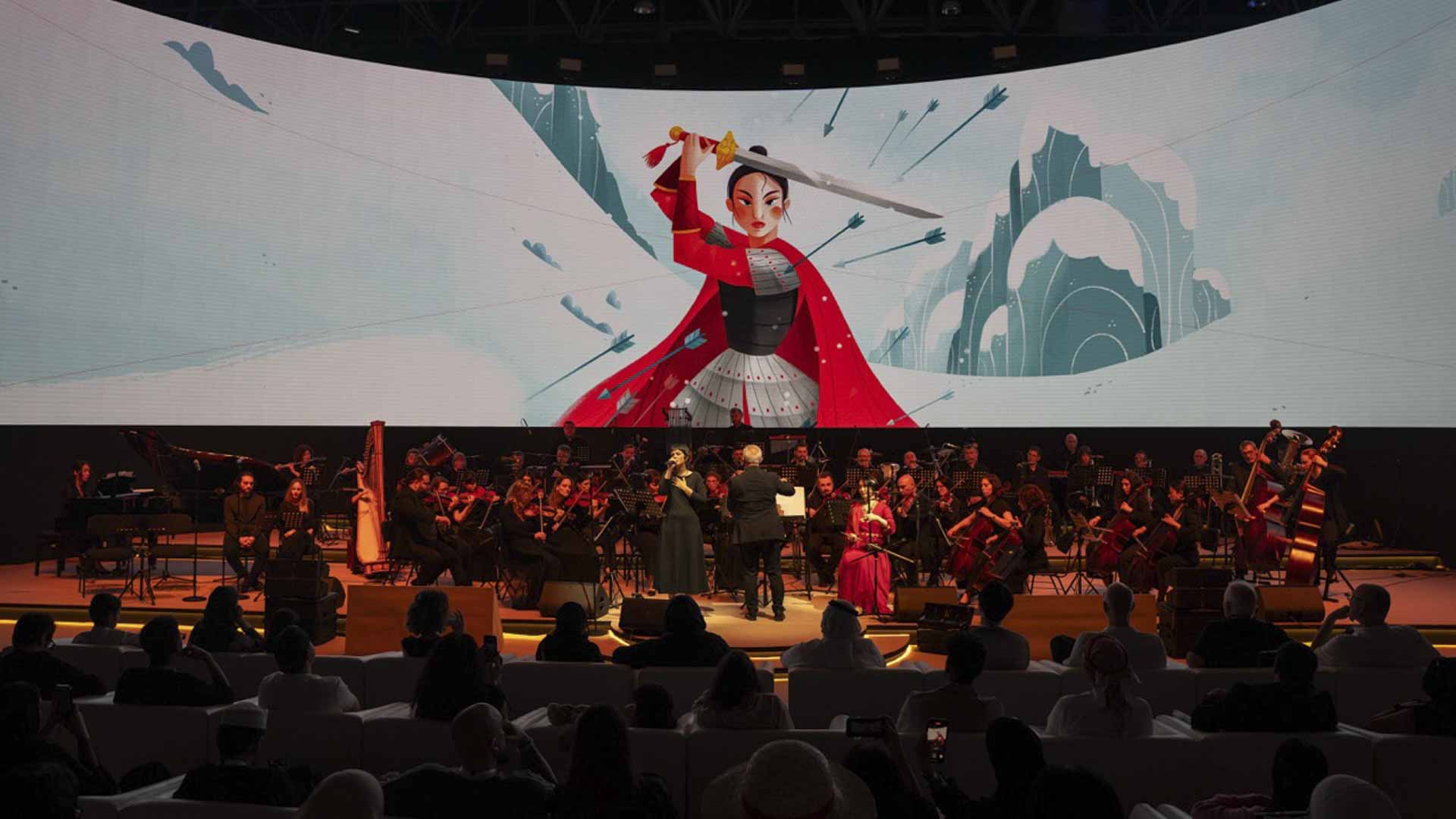 A full orchestra performing on a stage with cinematic lighting during a concert at the Sharjah Animation & Comics